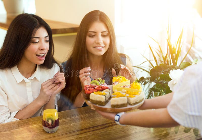 Tv? flickor som v? ljer sunda och smakliga vegetariska kakor royaltyfri bild