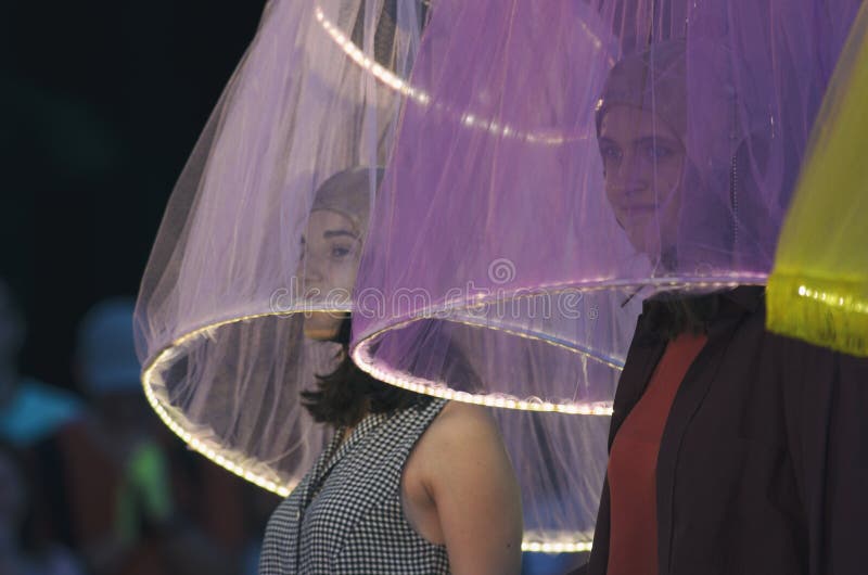 Två flickor under den genomskinliga lampskärmen med nattbelysning royaltyfri bild Två flickor under den genomskinliga lampskärmen med nattbelysning royaltyfri bild