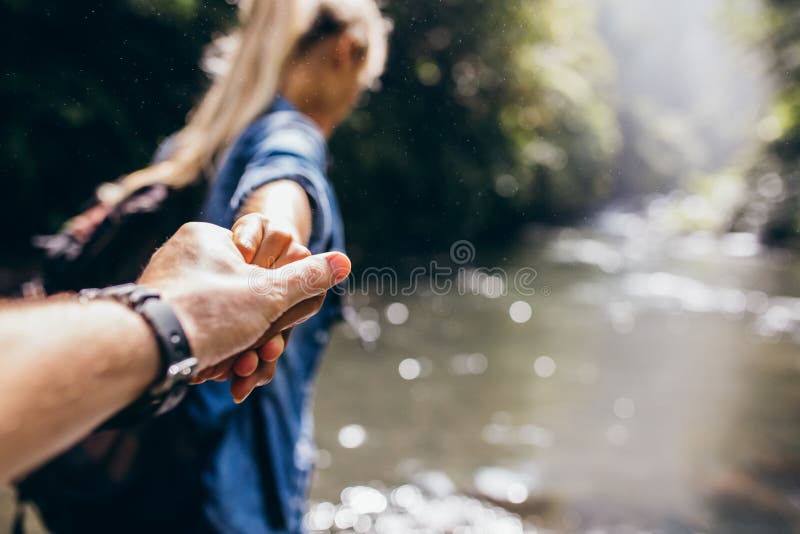 Två fotvandrare i natur som korsar ströminnehavhänderna fotografering för bildbyråer Två fotvandrare i natur som korsar ströminnehavhänderna fotografering för bildbyråer