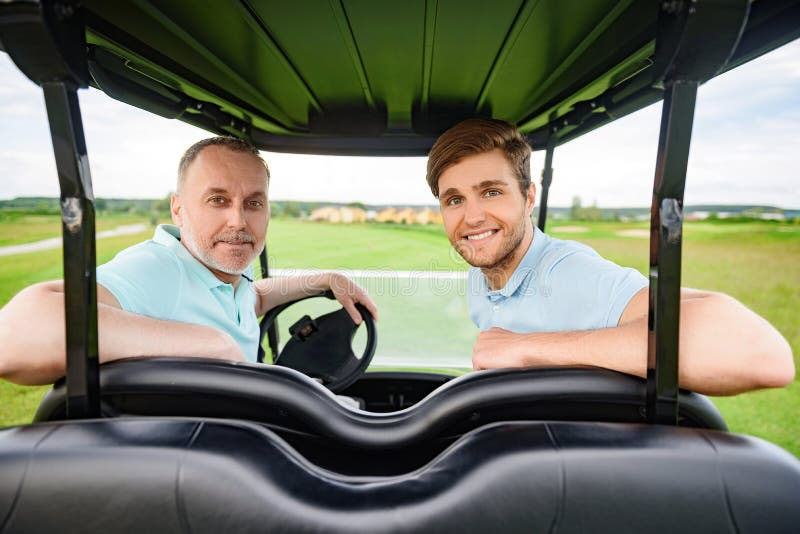 Två golfare som sitter i vagn royaltyfri bild Två golfare som sitter i vagn royaltyfri bild