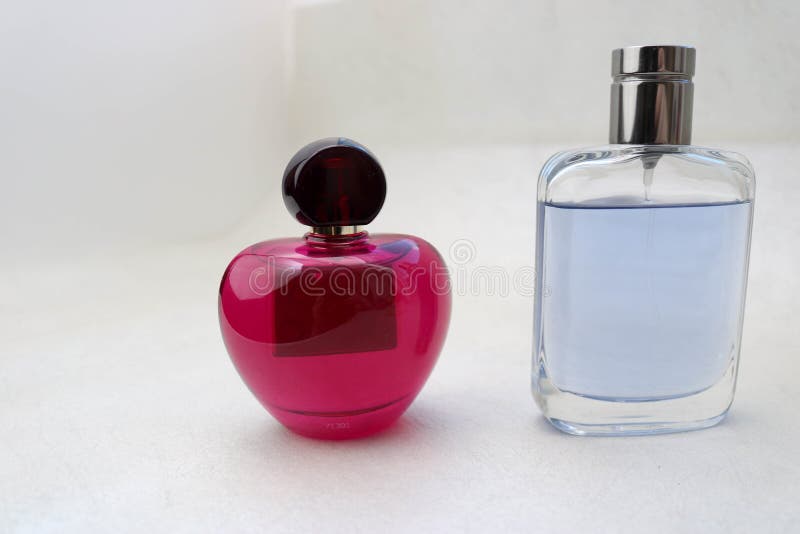 Två härliga glass genomskinliga skinande trendiga glamorösa små medicinflaskor av eau-de-cologne, doftrosa färger och blått med s royaltyfria foton Två härliga glass genomskinliga skinande trendiga glamorösa små medicinflaskor av eau-de-cologne, doftrosa färger och blått med s royaltyfria foton