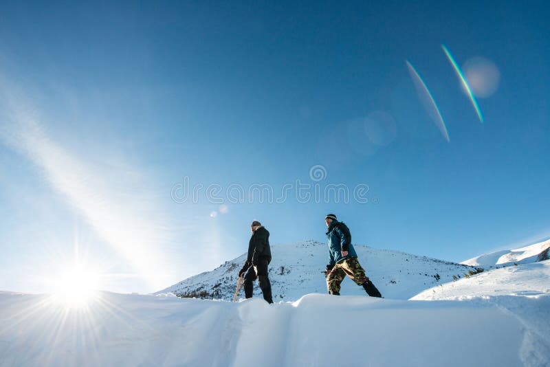 Två klättrare med en isyxa som går i de snöig bergen fotografering för bildbyråer Två klättrare med en isyxa som går i de snöig bergen fotografering för bildbyråer