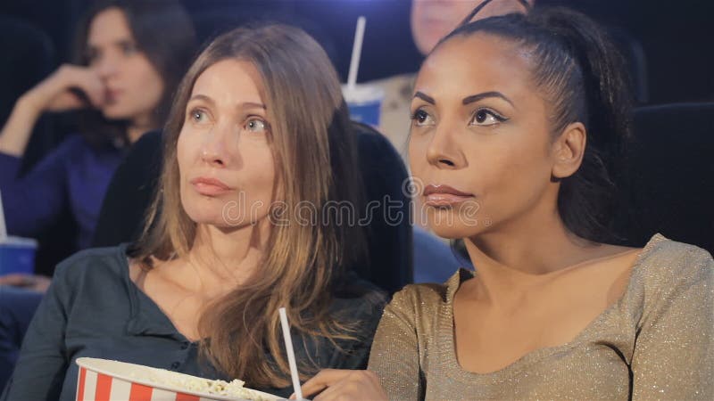 Två kvinnor som ser skärmen på filmbiografen