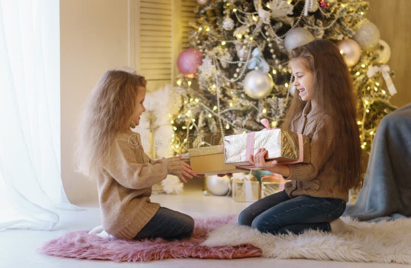 Två lilla systrar på julgranen royaltyfri fotografi