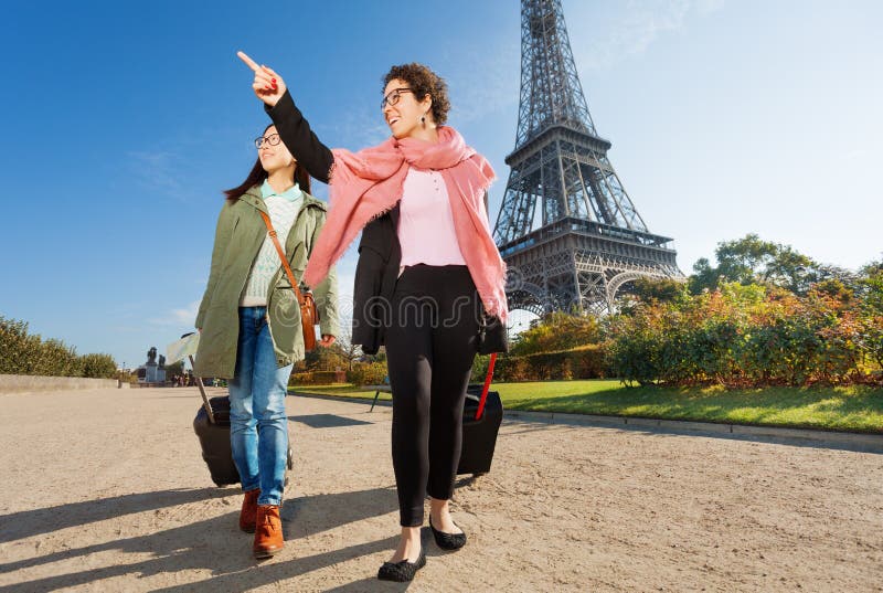 Två lyckliga kvinnliga turister som går runt om Paris fotografering för bildbyråer Två lyckliga kvinnliga turister som går runt om Paris fotografering för bildbyråer