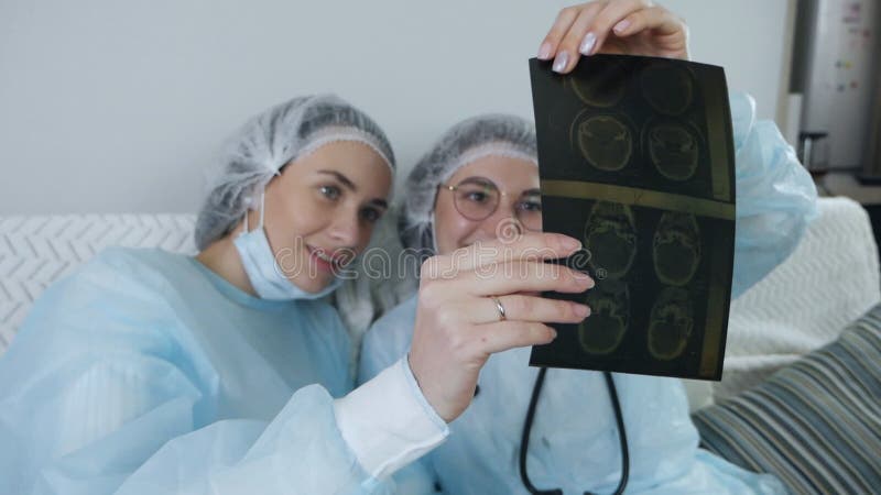 Två läkare undersöker en patientes röntgendiagnostik under en tepaus stock video