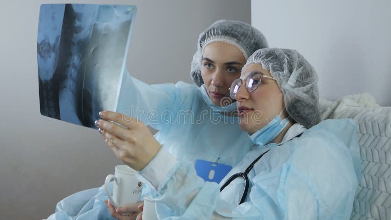 Två läkare undersöker patientens matriser för att få en diagnos under ett uppehåll lager videofilmer