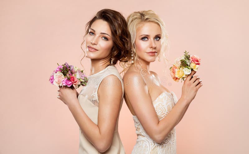 Två modemodeller med ståenden för blommabukettskönhet, härligt kvinnastudioskott med Rose Flower i hår