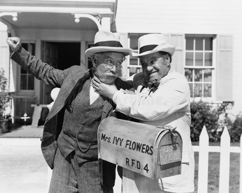 Two mature men fighting near a mail box in front of a house (All persons depicted are no longer living and no estate exists. Supplier grants that there will be no model release issues.). Two mature men fighting near a mail box in front of a house (All persons depicted are no longer living and no estate exists. Supplier grants that there will be no model release issues.)