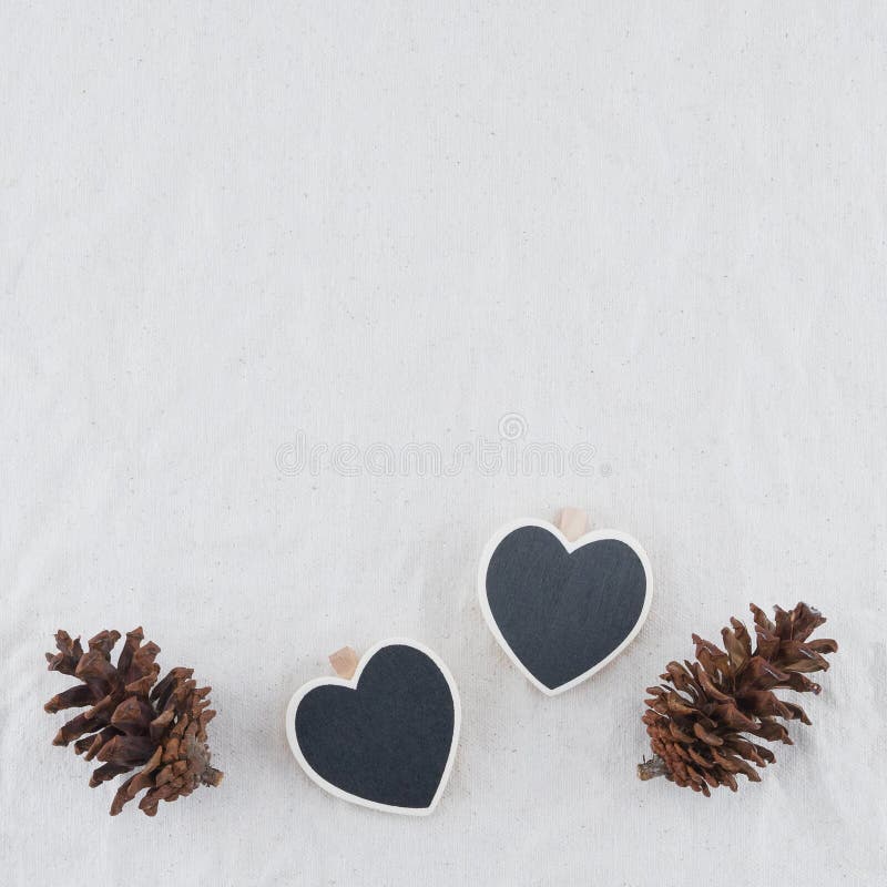 Två mycket lilla hjärtaformsvart tavla med pinecones royaltyfri fotografi Två mycket lilla hjärtaformsvart tavla med pinecones royaltyfri fotografi
