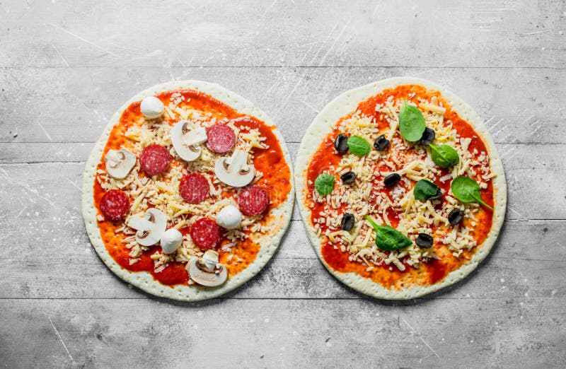 Två olika rå pizza royaltyfri fotografi Två olika rå pizza royaltyfri fotografi