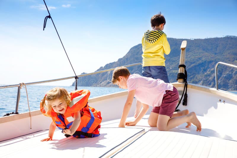 Två pojkar för liten unge och litet barnflicka som tycker om segelbåttur Familjsemestrar p? havet eller havet p? solig dag Barn royaltyfria foton Två pojkar för liten unge och litet barnflicka som tycker om segelbåttur Familjsemestrar p? havet eller havet p? solig dag Barn royaltyfria foton