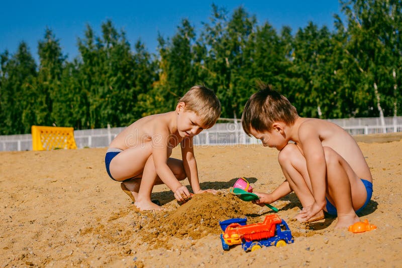 Två pojkar som spelar i sanden arkivfoto Två pojkar som spelar i sanden arkivfoto