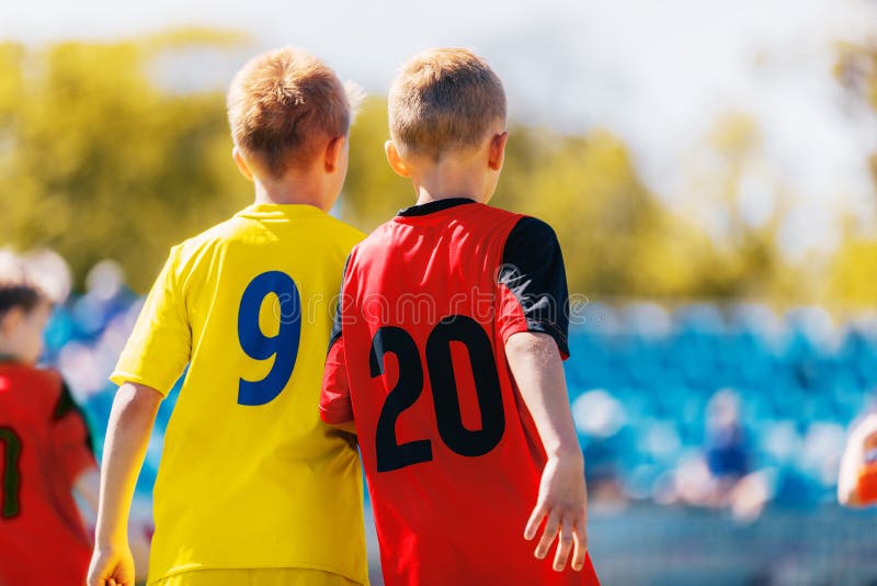 Två pojkefotbollspelare i färgglade Jersey skjortor Ungebarn konkurrerar i sportkonkurrens arkivfoton Två pojkefotbollspelare i färgglade Jersey skjortor Ungebarn konkurrerar i sportkonkurrens arkivfoton