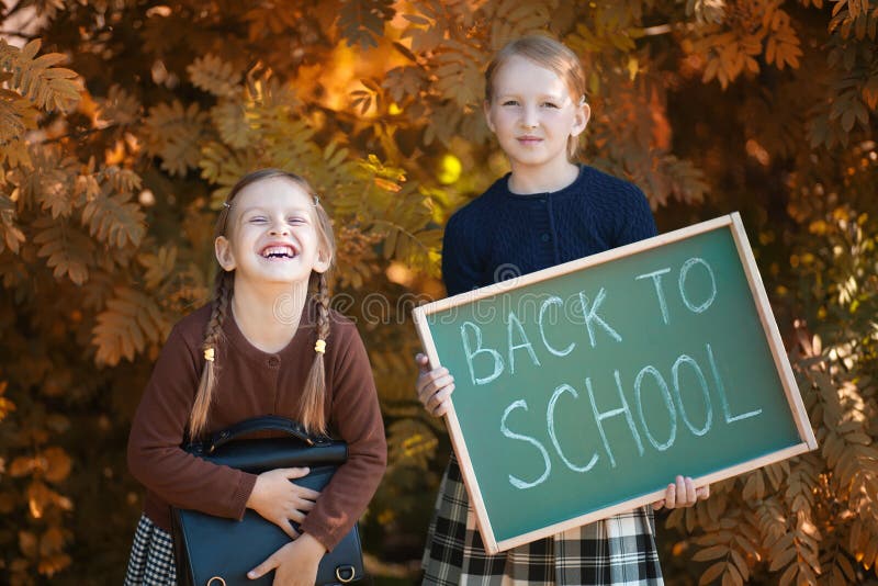 Två små flickor ordnar till tillbaka till skolan arkivfoto Två små flickor ordnar till tillbaka till skolan arkivfoto