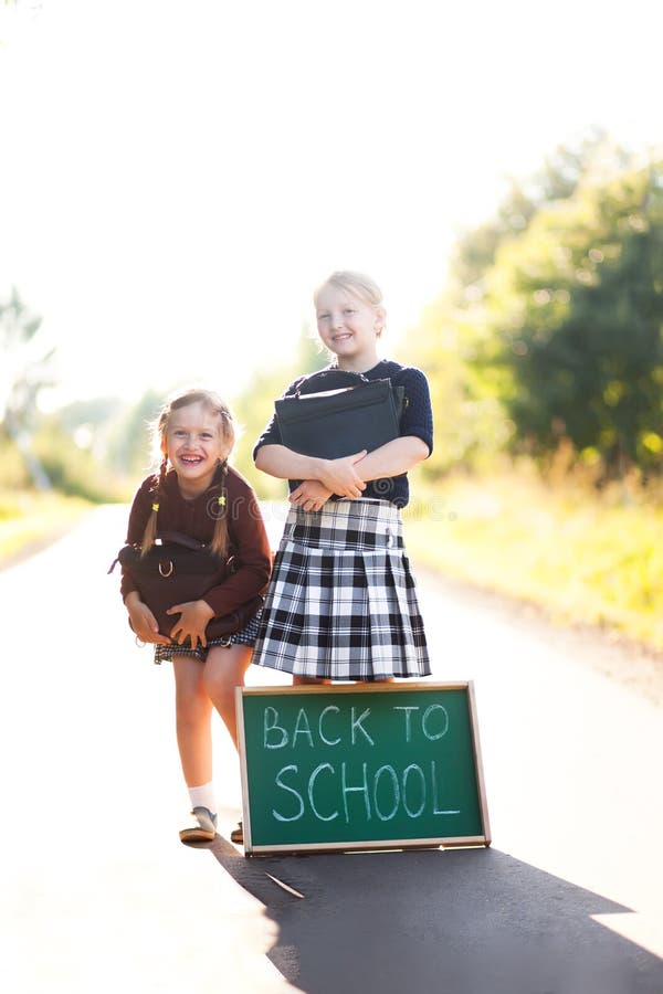 Två små flickor ordnar till tillbaka till skolan arkivfoto Två små flickor ordnar till tillbaka till skolan arkivfoto