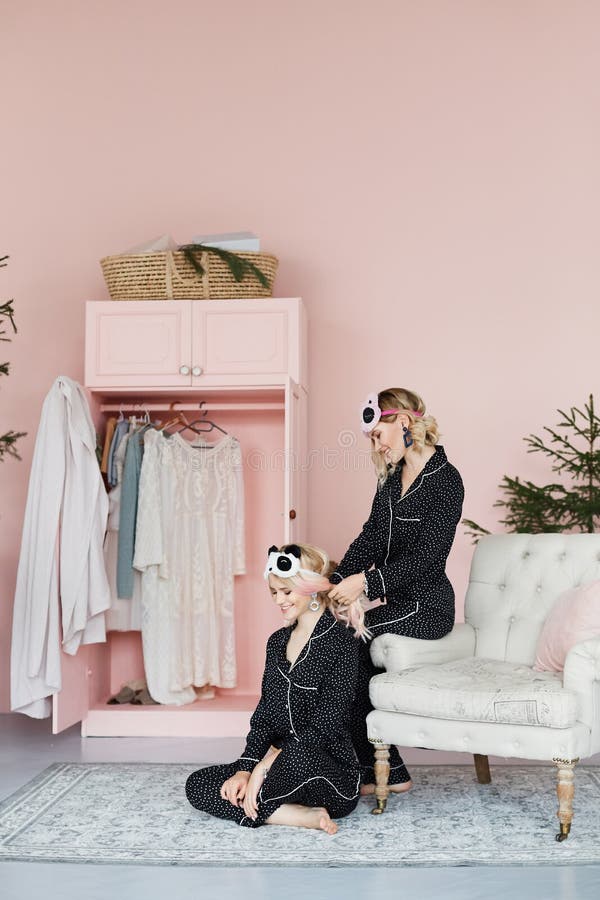 Två som är härliga som är lyckliga och ler blonda modellflickor i trendig pyjamas och i stilfulla sova maskeringar i form av arkivfoton Två som är härliga som är lyckliga och ler blonda modellflickor i trendig pyjamas och i stilfulla sova maskeringar i form av arkivfoton