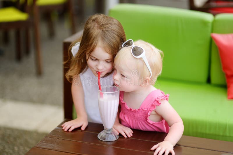 Två systrar som dricker milkshake royaltyfria foton Två systrar som dricker milkshake royaltyfria foton