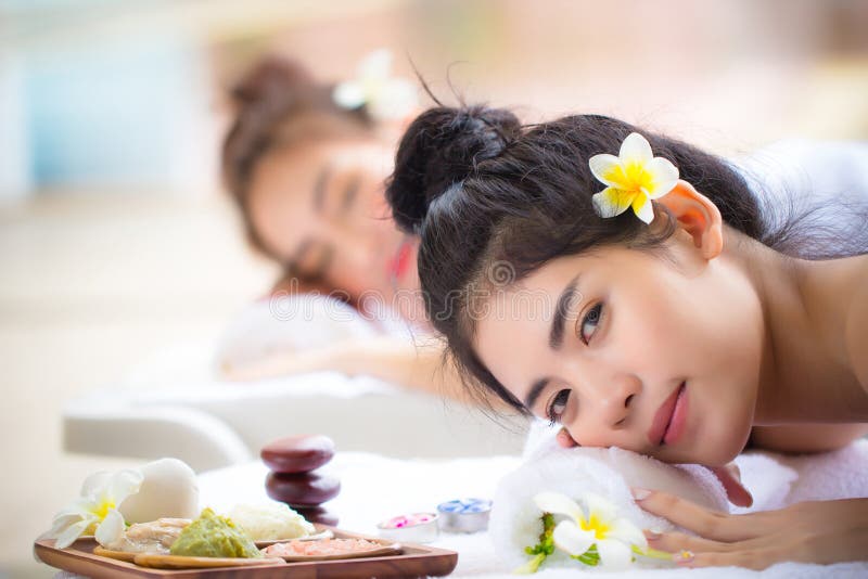 Två unga asiatiska kvinnor som leker i spa salon Skönhetstjänst med vänner på spa-bädd royaltyfri fotografi Två unga asiatiska kvinnor som leker i spa salon Skönhetstjänst med vänner på spa-bädd royaltyfri fotografi