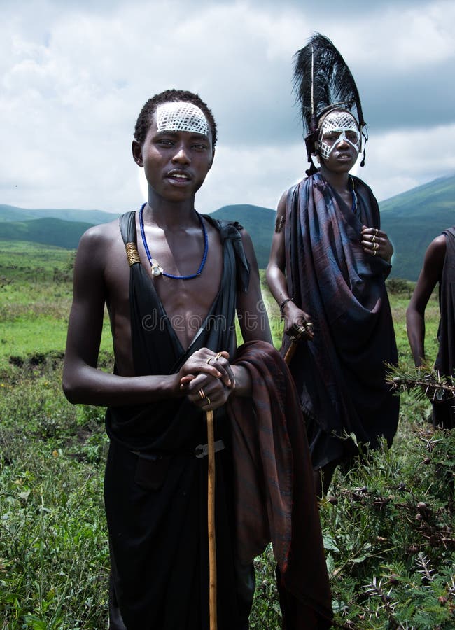 Två unga Maasai krigare eller yngre Morans, med huvudbonaden och teckning royaltyfria foton Två unga Maasai krigare eller yngre Morans, med huvudbonaden och teckning royaltyfria foton