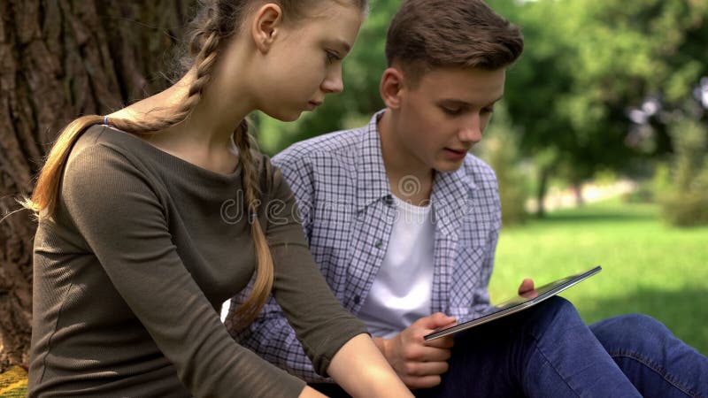Två upprivna studenter som söker viktig information för studie på minnestavlan, grej fotografering för bildbyråer