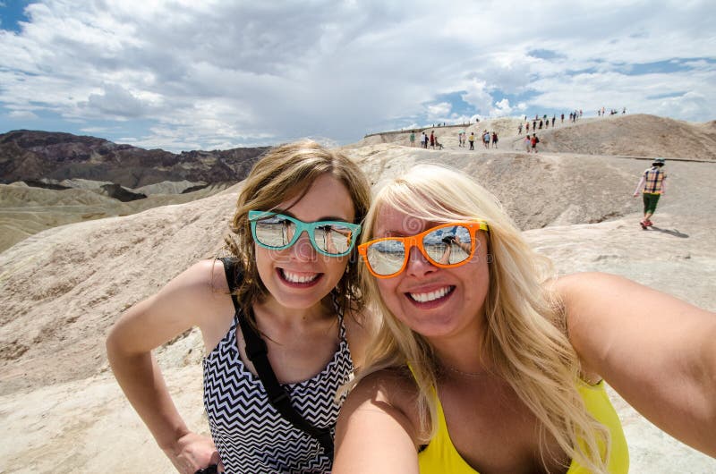 Två vuxna kvinnlig tar en selfie medan på Zabriskie punktutkik i den Kalifornien Death Valley nationalparken royaltyfri bild Två vuxna kvinnlig tar en selfie medan på Zabriskie punktutkik i den Kalifornien Death Valley nationalparken royaltyfri bild