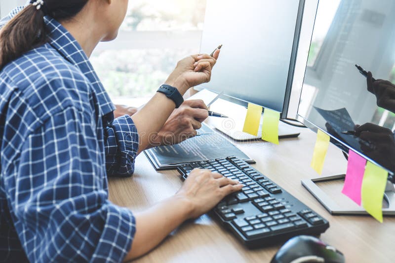 Två yrkesmässiga programmerare som samarbetar på den framkallande programmera och websiten som arbetar i en programvara, framkall arkivbild Två yrkesmässiga programmerare som samarbetar på den framkallande programmera och websiten som arbetar i en programvara, framkall arkivbild