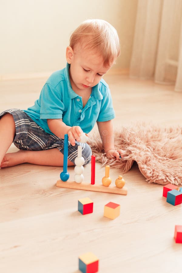 Två år gamla barnpojkar som leker med pedagogiska spel arkivbilder