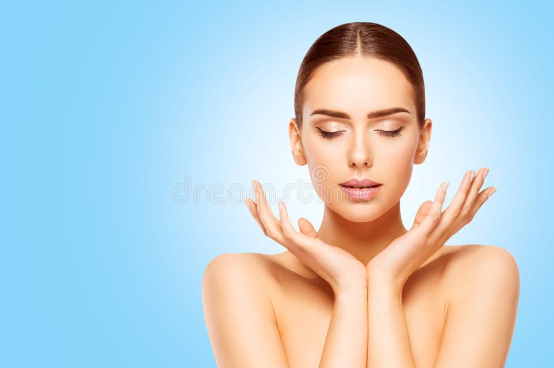 Face and Hands Beauty Skin Care, Woman Natural Make Up, Model looking to Product on Hand over Blue Background. Face and Hands Beauty Skin Care, Woman Natural Make Up, Model looking to Product on Hand over Blue Background