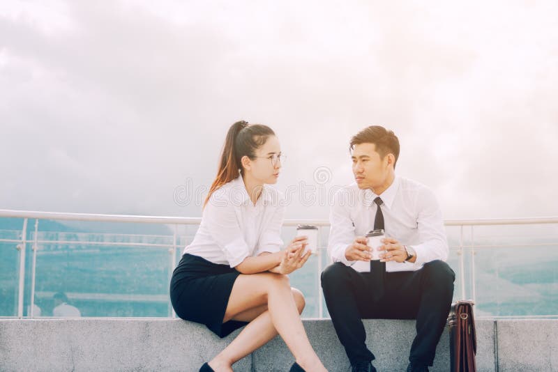 Twee Aziatische bedrijfsmensen die buiten bedrijf met holding c spreken royalty-vrije stock afbeelding Twee Aziatische bedrijfsmensen die buiten bedrijf met holding c spreken royalty-vrije stock afbeelding