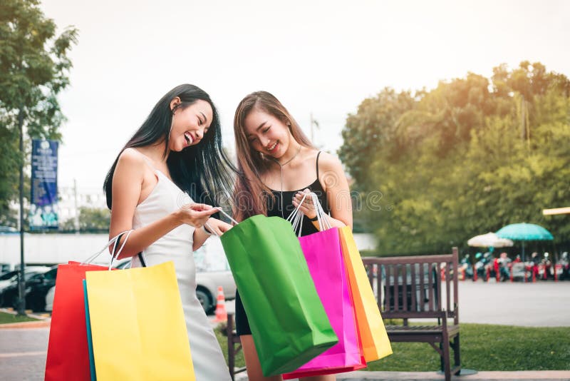 Twee Aziatische vrouwen die zich bij afzetwandelgalerij bevinden en binnenshopp kijken stock foto's Twee Aziatische vrouwen die zich bij afzetwandelgalerij bevinden en binnenshopp kijken stock foto's