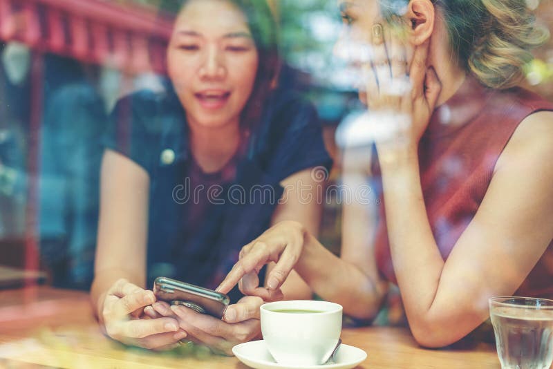 Twee Aziatische vrouwen, vrienden die een vrije tijd het drinken koffie hebben bij koffie Vrienden die samen terwijl het drinken royalty-vrije stock foto's Twee Aziatische vrouwen, vrienden die een vrije tijd het drinken koffie hebben bij koffie Vrienden die samen terwijl het drinken royalty-vrije stock foto's