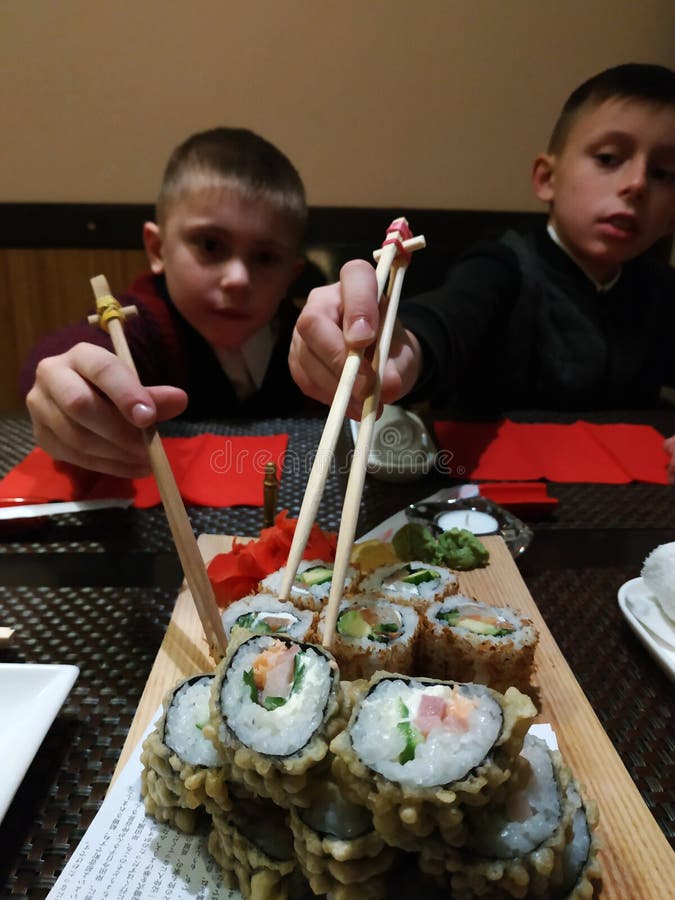 Twee broers eten thuis sushibroodjes royalty-vrije stock afbeeldingen Twee broers eten thuis sushibroodjes royalty-vrije stock afbeeldingen