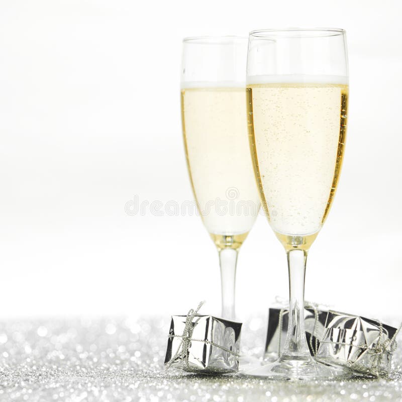 Two champagne flutes and gifts on shiny background. Two champagne flutes and gifts on shiny background