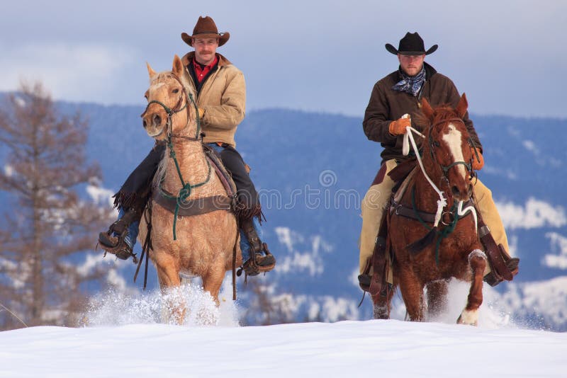 Twee cowboys die in diepe sneeuw berijden royalty-vrije stock fotografie Twee cowboys die in diepe sneeuw berijden royalty-vrije stock fotografie