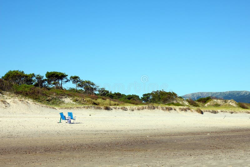 Twee eenzame stoelen op een leeg strand royalty-vrije stock afbeelding Twee eenzame stoelen op een leeg strand royalty-vrije stock afbeelding