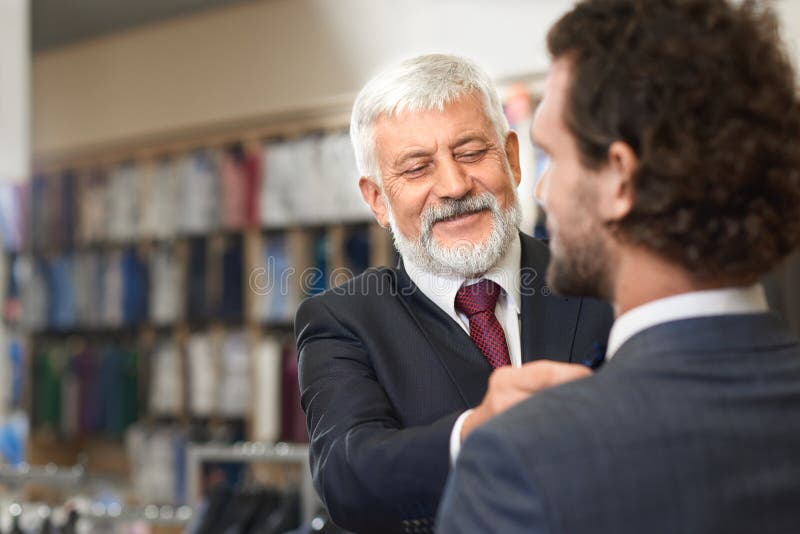 Twee elegante mensen die boutique komen vormen bij het winkelen stock afbeeldingen Twee elegante mensen die boutique komen vormen bij het winkelen stock afbeeldingen