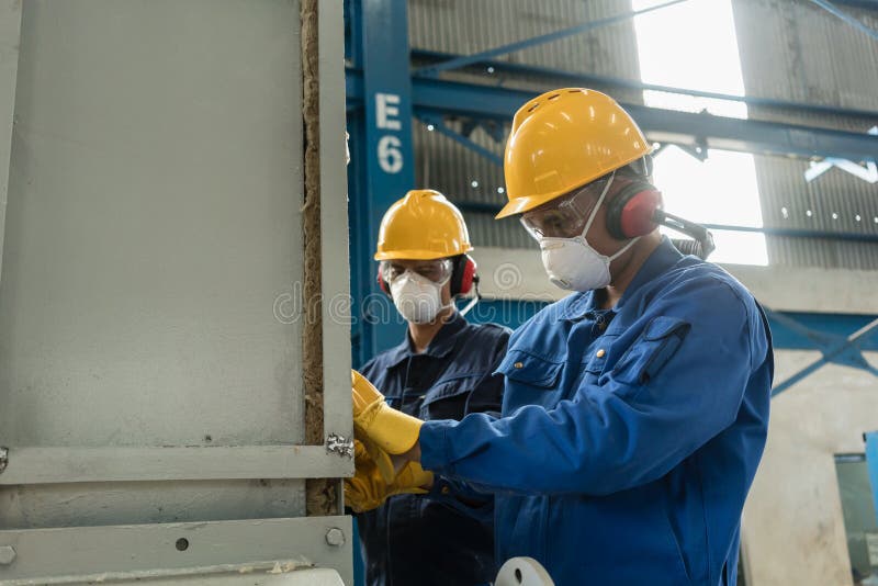 Twee fabrieksarbeiders die beschermingsmiddel dragen