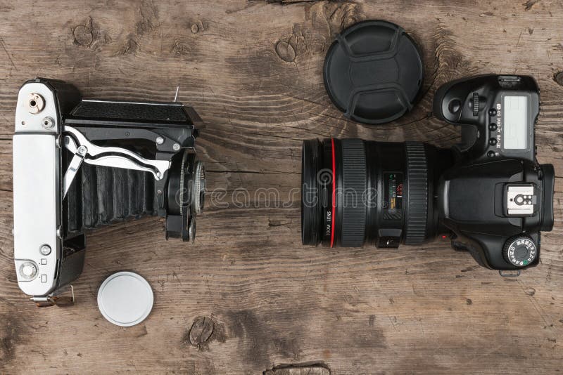 Twee fotocamera's op oude houten lijst, hoogste mening Vergelijking van verschillende generaties van het fotograferen van materia royalty-vrije stock afbeelding Twee fotocamera's op oude houten lijst, hoogste mening Vergelijking van verschillende generaties van het fotograferen van materia royalty-vrije stock afbeelding