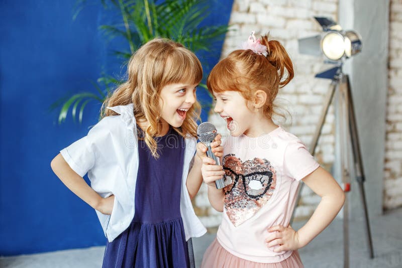 Twee gelukkige kleine kinderen zingen een lied in karaoke Het concept is stock foto Twee gelukkige kleine kinderen zingen een lied in karaoke Het concept is stock foto