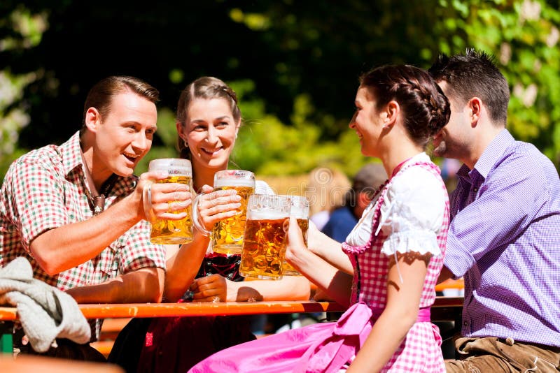 Twee gelukkige paren die in de tuin van het Bier zitten royalty-vrije stock foto's Twee gelukkige paren die in de tuin van het Bier zitten royalty-vrije stock foto's