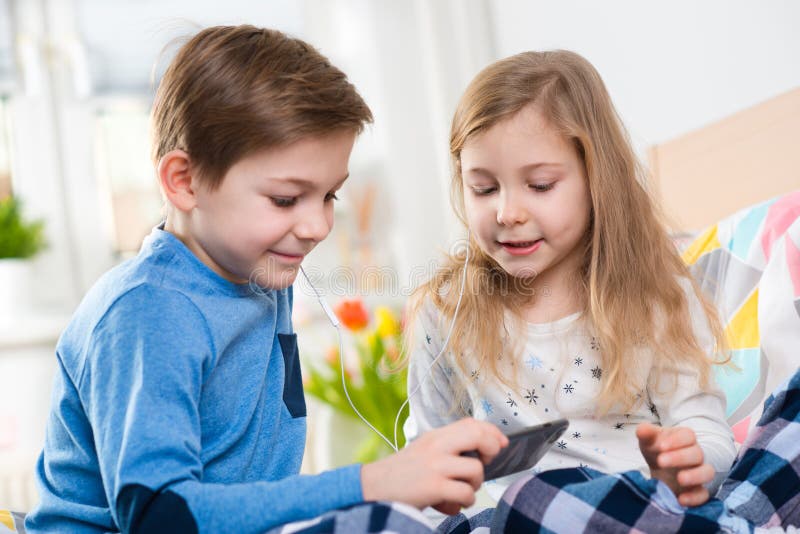 Twee gelukkige siblings kinderen die pret en het luisteren muziek hebben met stock fotografie Twee gelukkige siblings kinderen die pret en het luisteren muziek hebben met stock fotografie