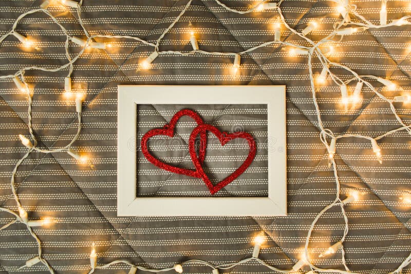 Twee harten in fotokader over plaid met lichten, comfort en Romaans concept met geschiedenis royalty-vrije stock fotografie Twee harten in fotokader over plaid met lichten, comfort en Romaans concept met geschiedenis royalty-vrije stock fotografie