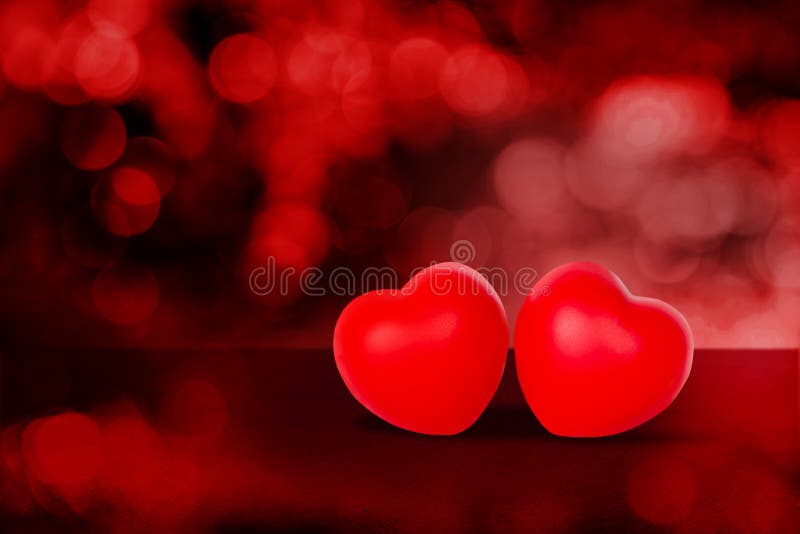 Twee hartvormen op de rode bokeh achtergrond abstract met glitter glanzend 14 februari valentijndag.