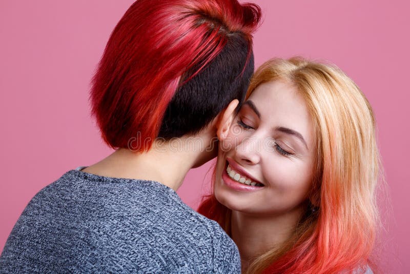 Twee het gelukkige lesbische meisjes omhelzen Op een roze achtergrond stock afbeeldingen Twee het gelukkige lesbische meisjes omhelzen Op een roze achtergrond stock afbeeldingen