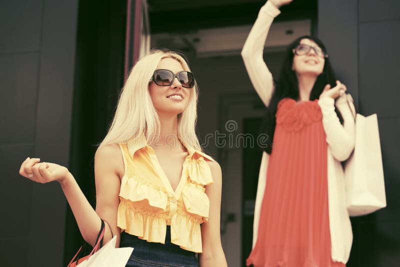 Twee jonge maniervrouwen met het winkelen zakken bij de wandelgalerij stock foto's Twee jonge maniervrouwen met het winkelen zakken bij de wandelgalerij stock foto's