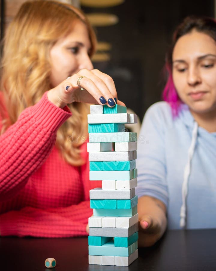Twee jonge vrouwen die gekleurde jenga spelen stock afbeelding Twee jonge vrouwen die gekleurde jenga spelen stock afbeelding