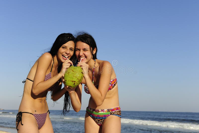 Twee jonge vrouwen die kokosnotenwater drinken stock afbeelding Twee jonge vrouwen die kokosnotenwater drinken stock afbeelding