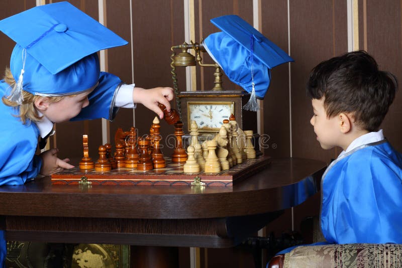 Two boys in blue suits start to a game of chess. Two boys in blue suits start to a game of chess