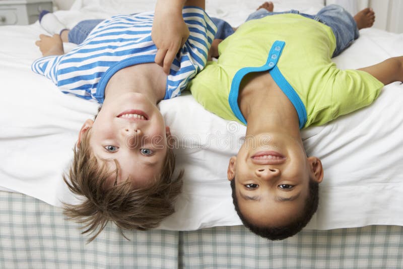 Twee Jongens die op Bed samen spelen royalty-vrije stock fotografie Twee Jongens die op Bed samen spelen royalty-vrije stock fotografie